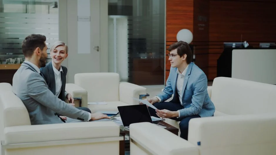 our-story Person analyzes stock data with a smartphone and laptop, indoors.
